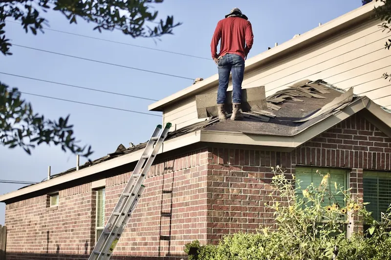Professional roofer working on a residential roof in Butts